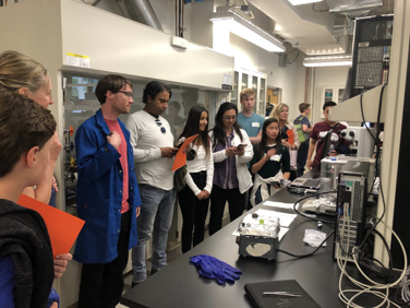 Figure 1.  Students and parents learn about chemical analysis and microscopy from Dr. Alexander Dupuy, a postdoctoral scholar supervised by Prof. Julie Schoenung.